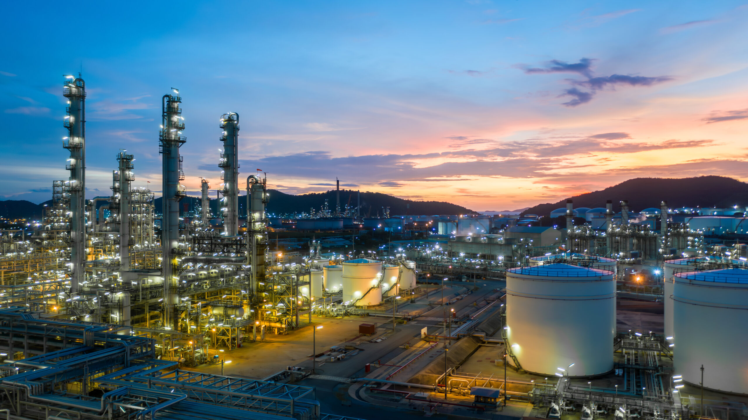 Luftaufnahme Öl- und Gastank mit Ölraffinerie Hintergrund bei Nacht, Glitter Beleuchtung der petrochemischen Anlage mit Nacht, Herstellung von Erdöl, Produkte Tank in petrochemischen Anlage.